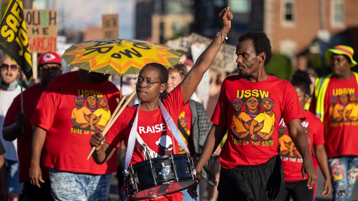 Tashira Smith plays the drum as she lead a march of demonstrators from the CCB Plaza to Duke University along N. Main Street calling for calling for a $25 an hour wage for all, during a May Day March on Wednesday, May 1, 2024 in Durham, N.C.