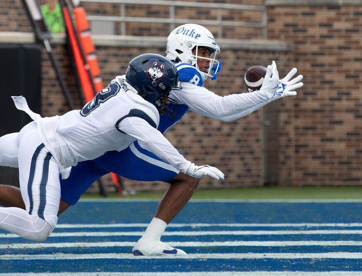 Duke’s Jordan Moore lunges past Connecticut’s D’Mon Brinson to score a touchdown during the first half of the Blue Devils’ game against UConn on Saturday, Sept. 14, 2024, at Wallace Wade Stadium in Durham, N.C.