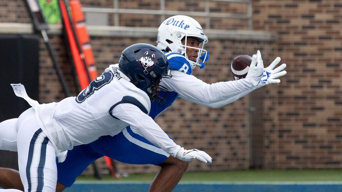 Duke’s Jordan Moore lunges past Connecticut’s D’Mon Brinson to score a touchdown during the first half of the Blue Devils’ game against UConn on Saturday, Sept. 14, 2024, at Wallace Wade Stadium in Durham, N.C.