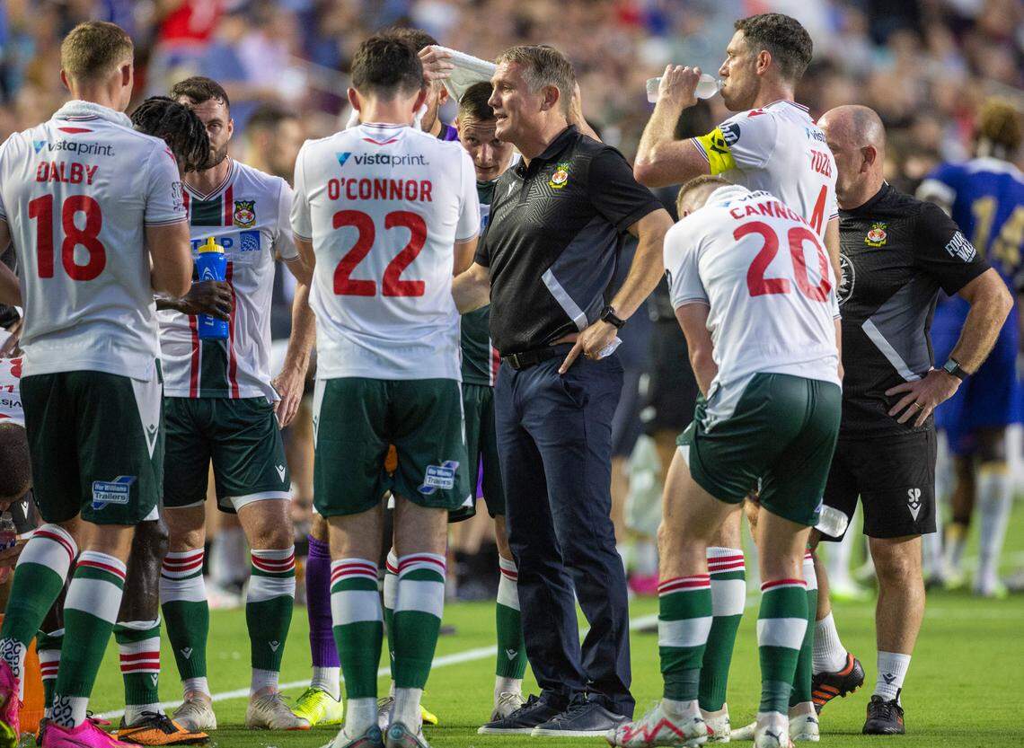 Wrexham head coach Phil Parkinson talks with his players during a mandatory cooling off period in the first half against Chelsea during their FC Series game on Wednesday, July 19, 2023 at Kenan Stadium in Chapel Hill, N.C.
