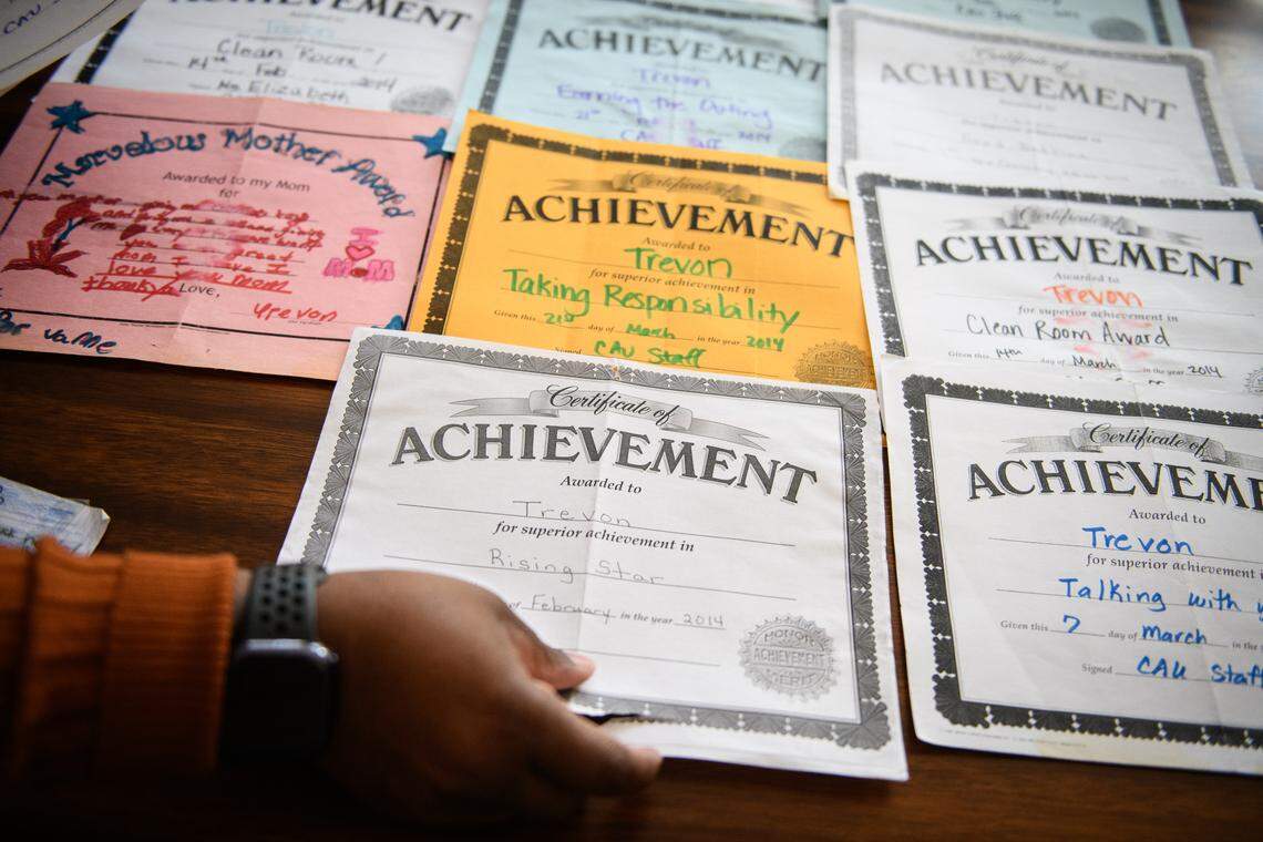 Jane shows off the many certificates of achievement that her son received.