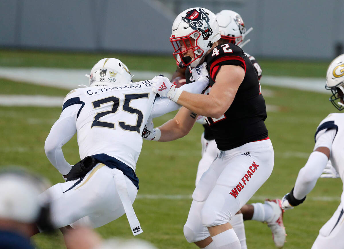 N.C. State tight end Dylan Autenrieth (42) blocks Georgia Tech defensive back Charlie Thomas (25) during the first half of N.C. State’s game against Georgia Tech at Carter-Finley Stadium in Raleigh, N.C., Saturday, Dec. 5, 2020.