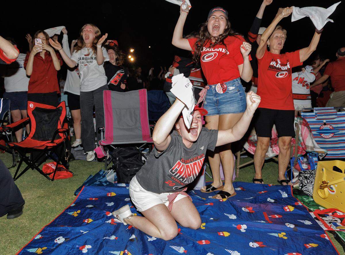 Emaly Bostaph, center, reacts following the Carolina Hurricanes’ overtime win over the Vegas Golden Knights in Game 2 of the Stanley Cup Final during a watch party in Moore Square on Thursday, June 4, 2026, in Raleigh, N.C.