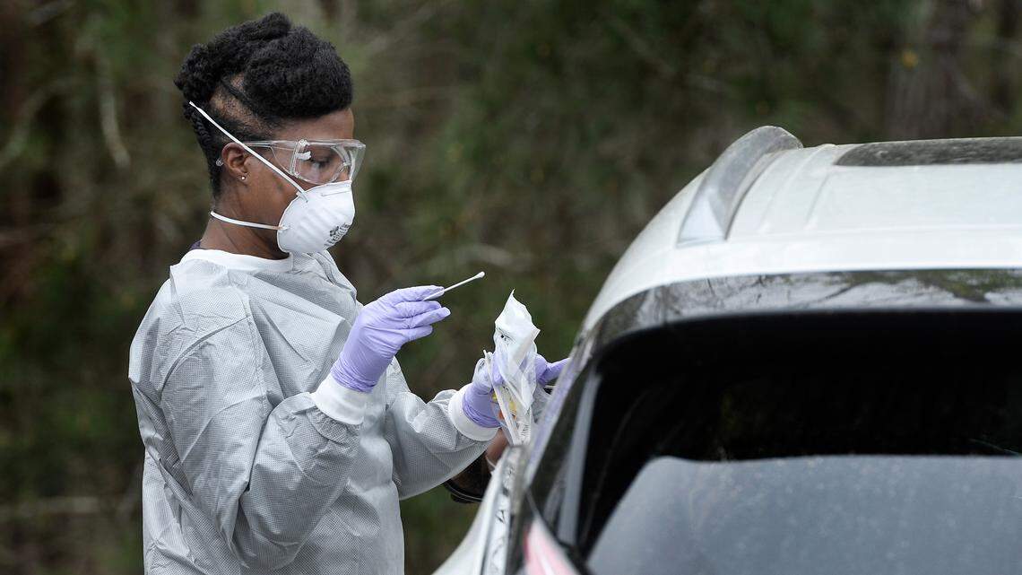 Family nurse practitioner Schquthia Peacock prepares to do a nasal swab to test for coronavirus with patient in her car in the parking lot of Preston Medical Associates in Cary, N.C. Tuesday afternoon, March 17, 2020. Patients who show symptoms of coronavirus are ask to wait in their cars for testing.