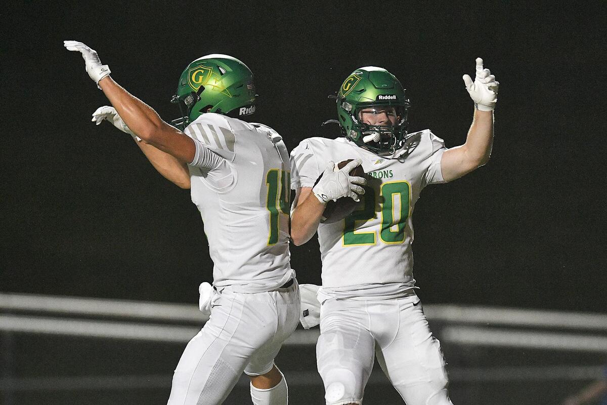 Cardinal Gibbons’ Chet Yardley (14) celebrates with Joey Jonske (20) after his touchdown in the first half. The Cardinal Gibbons Crusaders and the Athens Drive Jaguars met in a conference football game in Raleigh , N.C. on September 29, 2023.