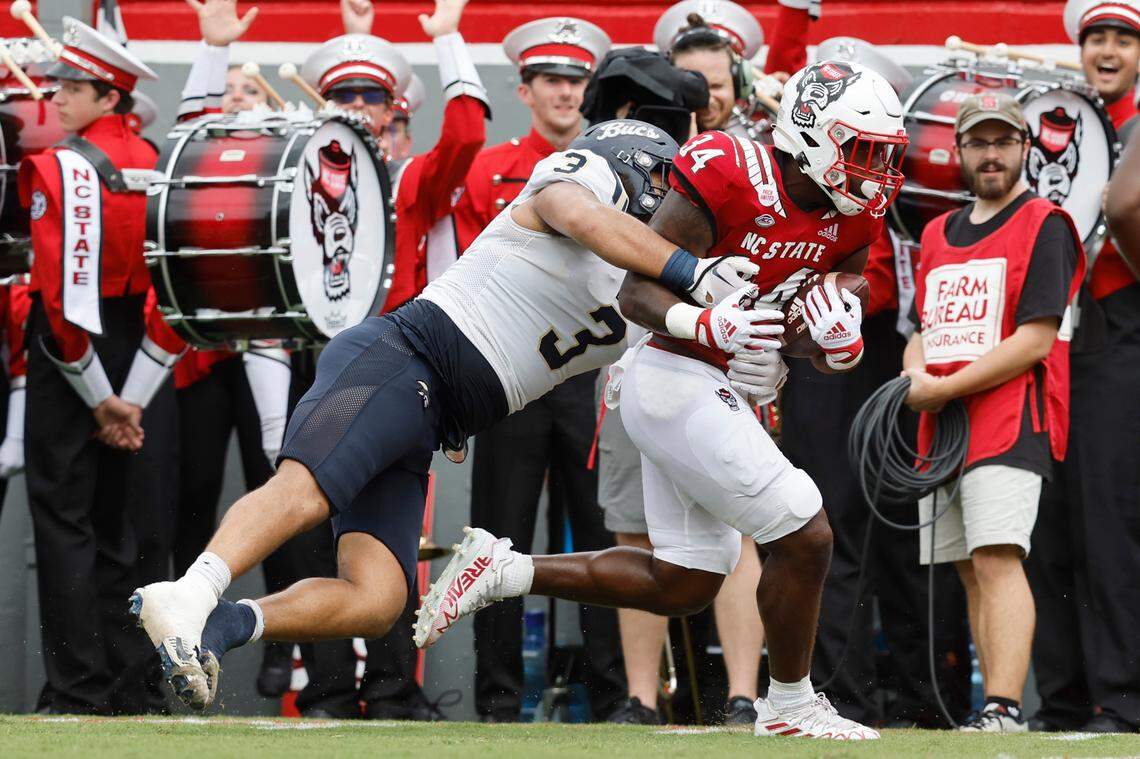N.C. State running back Delbert Mimms III (34) scores on a 20-yard touchdown reception as Charleston Southern defensive lineman Quintin Seguin (3) tries to stop him during the first half of N.C. State’s game against Charleston Southern at Carter-Finley Stadium in Raleigh, N.C., Saturday, Sept. 10, 2022.