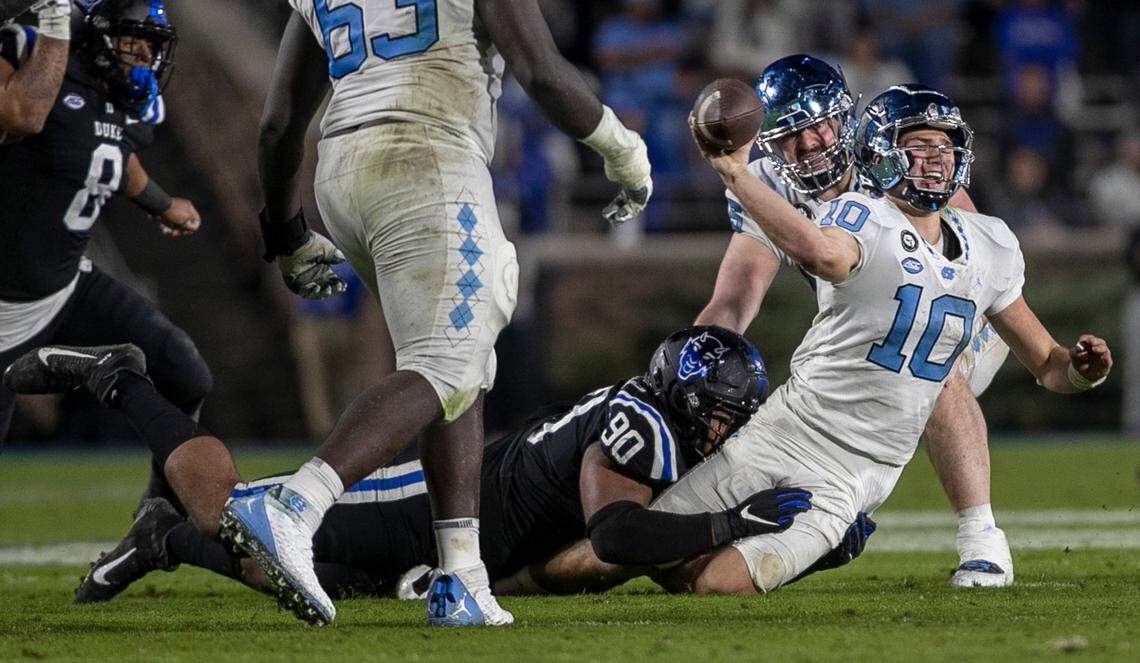 North Carolina quarterback Drake Maye (10) tries to get rid of the ball as he is sacked by Duke’s DeWayneCarter (90) for a nine yard loss during the Tar Heels’ final drive in the fourth quarter on Saturday, October 15, 2022 at Wallace-Wade Stadium in Durham, N.C.