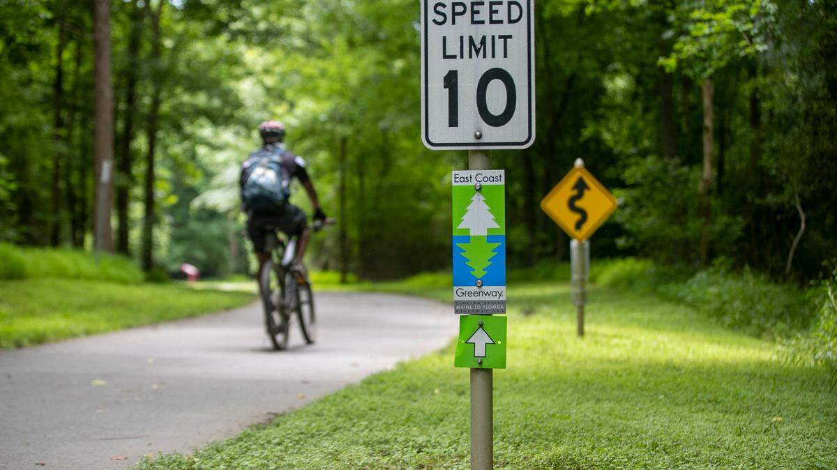 A cyclist uses the Neuse River Trail, part of the East Coast Greenway system on June 15, 2021, in Raleigh. Some lawmakers want to make more state money available for bike and pedestrian projects in North Carolina.