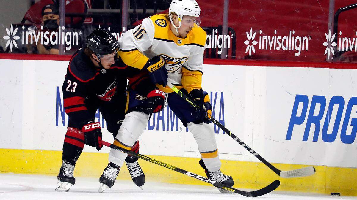Nashville Predators’ Rem Pitlick (16) battles with Carolina Hurricanes’ Brock McGinn (23) for the puck during the first period of an NHL hockey game in Raleigh, N.C., Tuesday, March 9, 2021. (AP Photo/Karl B DeBlaker)