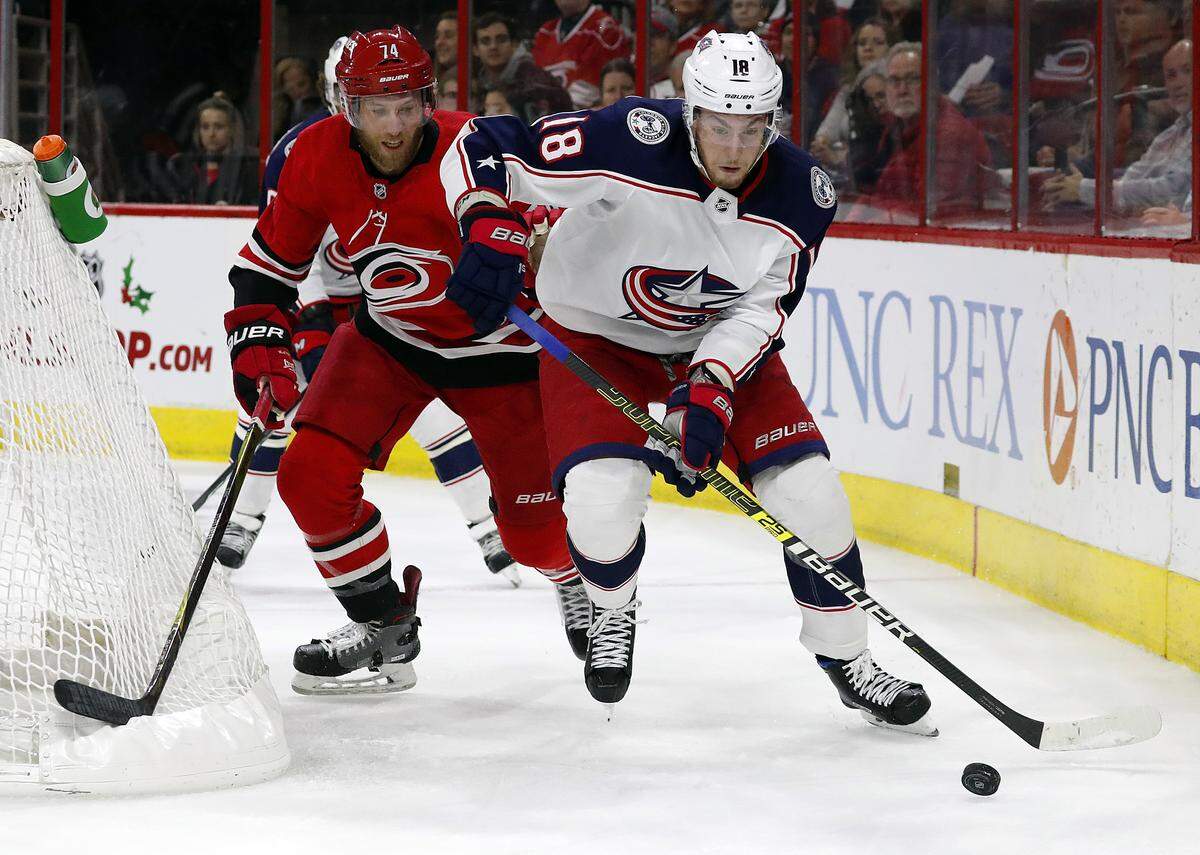 Columbus Blue Jackets’ Pierre-Luc Dubois (18) works the puck agains Carolina Hurricanes’ Jaccob Slavin (74) during the first period of an NHL hockey game, Saturday, Nov. 17, 2018