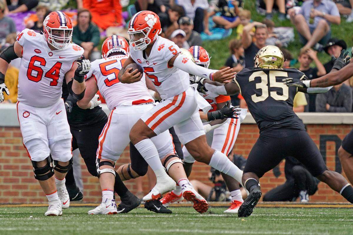 Clemson quarterback DJ Uiagalelei (5) runs past Wake Forest defensive lineman Kendron Wayman (35) during the first half of an NCAA college football game in Winston-Salem, N.C., Saturday, Sept. 24, 2022. (AP Photo/Chuck Burton)