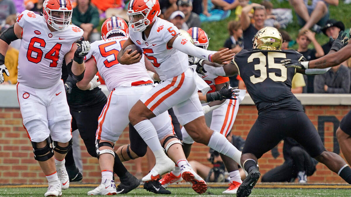 Clemson quarterback DJ Uiagalelei (5) runs past Wake Forest defensive lineman Kendron Wayman (35) during the first half of an NCAA college football game in Winston-Salem, N.C., Saturday, Sept. 24, 2022. (AP Photo/Chuck Burton)