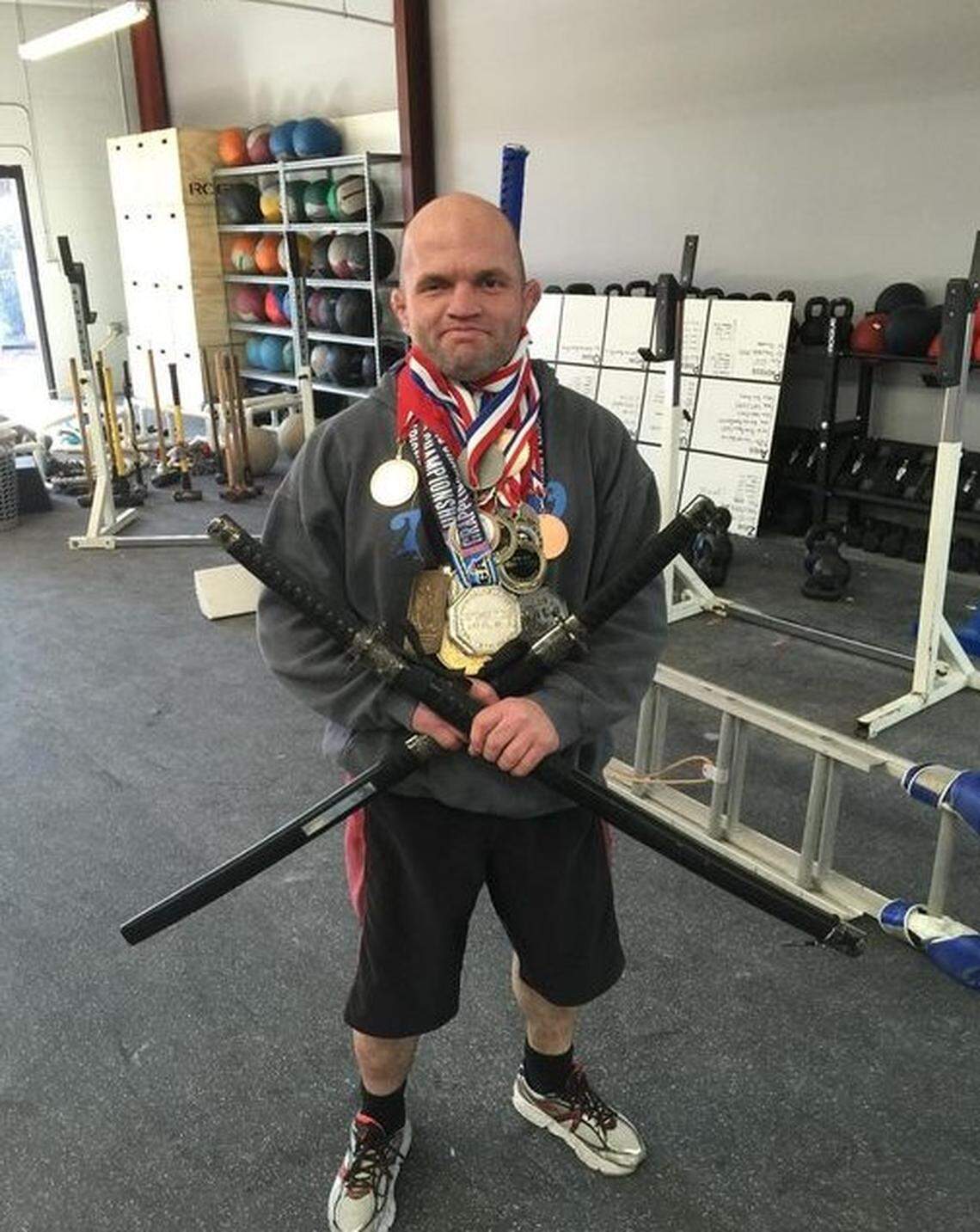 Ned Byrd stands covered in medals he won from Jiu Jitsu and CrossFit competitions at the Royce Gracie Jiu Jitsu of Cary Academy.