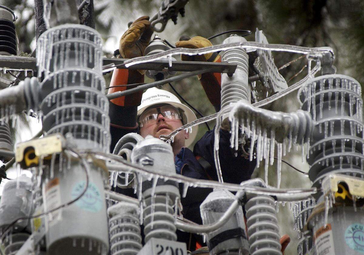 Power outages are a concern during the upcoming winter storm. In this 2002 photo, Progress Energy worker Len Turner repairs an ice-covered capacitor bank high on a pole on Ridge Road.