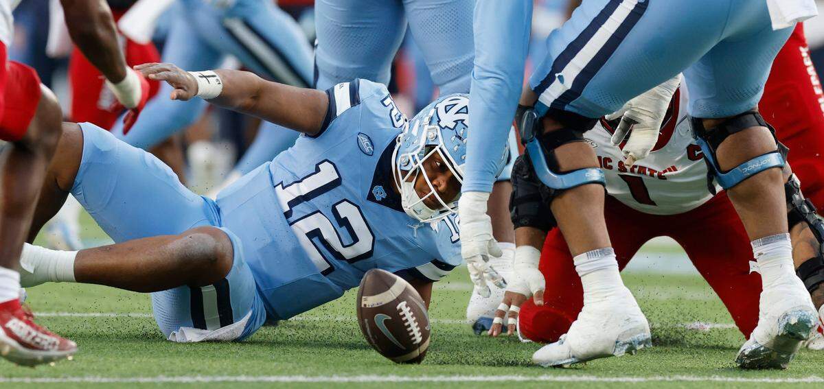 North Carolina quarterback Jacolby Criswell (12) looks for the ball after it was stripped from him during the first half of N.C. State’s game against UNC at Kenan Stadium in Chapel Hill, N.C., Saturday, Nov. 30, 2024. N.C. State would recover the fumble.