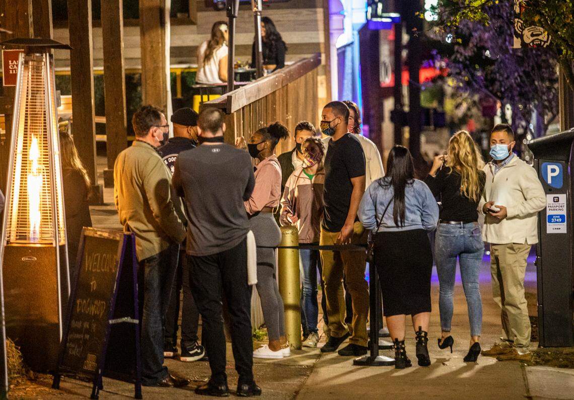Patrons wait in line outside The Dogwood Bar & Eatery In the Glenwood South bar and restaurant district in Raleigh Wednesday night, Nov. 25, 2020.