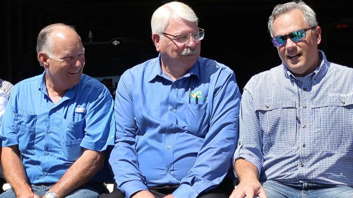 From left, Sen. Brent Jackson and Commissioner of Agriculture Steve Troxler chat with Lt. Gov. Dan Forest during a rally with farmers on Tuesday, July 10, 2018, at Joey Carter’s farm in Duplin County near Beulaville.