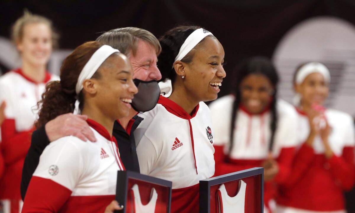 N.C. State head coach Wes Moore poses with seniors Kai Crutchfield, left, and Kayla Jones during senior day activities before N.C. State’s game against Pittsburgh at Reynolds Coliseum in Raleigh, N.C., Thursday, February 25, 2021.