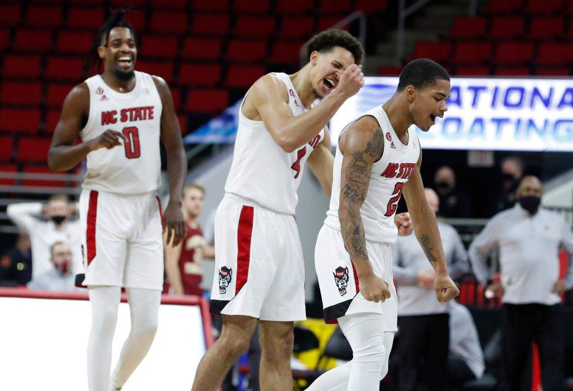 From left, N.C. State’s D.J. Funderburk (0), Jericole Hellems (4) and Shakeel Moore (2) celebrate after N.C. State’s 79-76 victory over Boston College at PNC Arena in Raleigh, N.C., Wednesday, December 30, 2020.