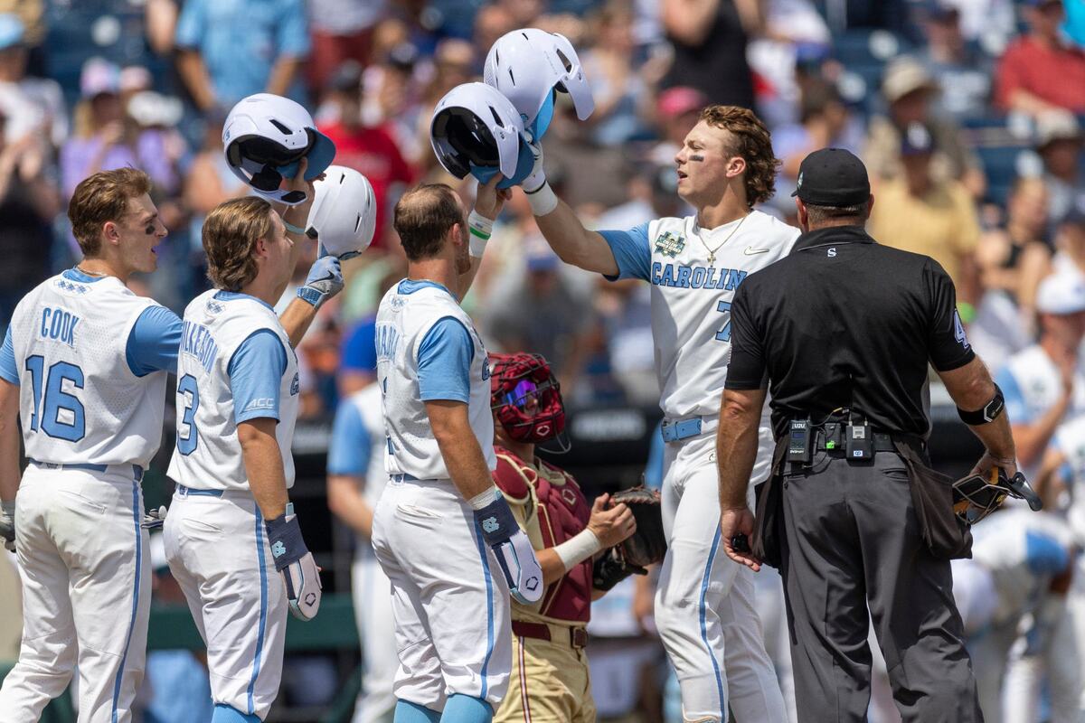 North Carolina outfielder Vance Honeycutt (7) is greeted at home plate by teammates Casey Cook (16), Colby Wilkerson (3) and Alex Madera (1) after connecting for a 3 RBI home run in the fifth inning during game nine of the College World Series on Tuesday, June 18, 2024 at Charles Schwab Field in Omaha, Nebraska.