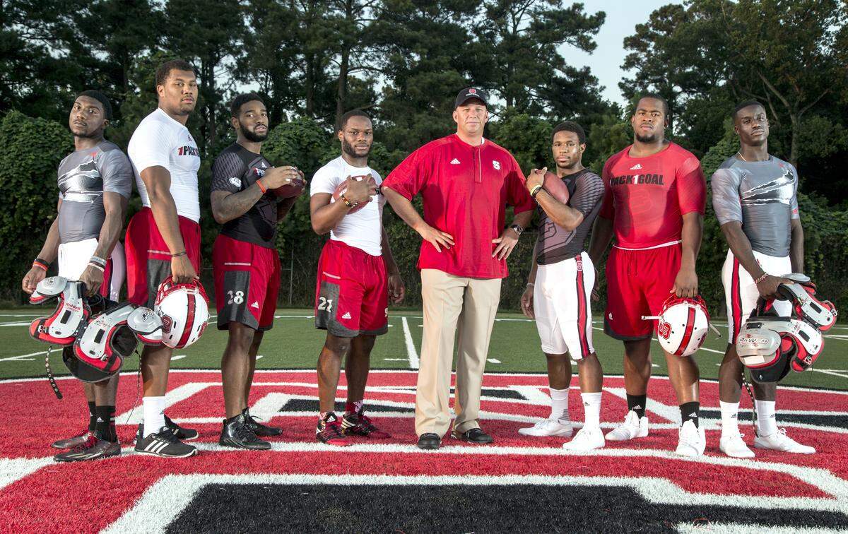 N.C. State football players, from left, Shawn Boone, Bradley Chubb, Jaylen Samuels, Matt Dayes, Coach Dave Doreen, Nyheim Hines, B.J. Hill and Jack Tocho pose in 2016.