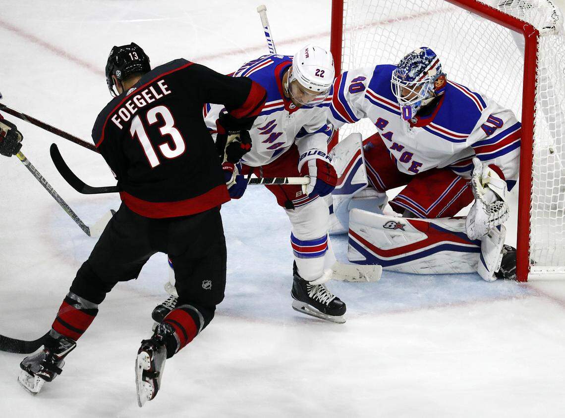 Carolina Hurricanes’ Warren Foegele (13) battles with New York Rangers’ Kevin Shattenkirk (22) in front of goaltender Alexandar Georgiev (40) during the third period of an NHL hockey game, Sunday, Oct. 7, 2018, in Raleigh, N.C. The Hurricanes’ won 8-5. 