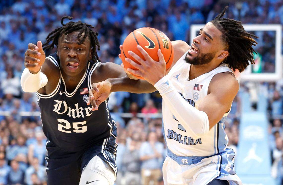 North Carolina’s RJ Davis (4) drives by Duke’s Mark Mitchell (25) during the first half of Duke’s game against UNC at the Smith Center in Chapel Hill, N.C., Saturday, Feb. 3, 2024.
