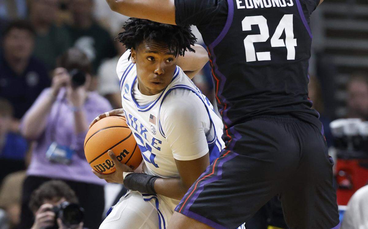 Duke’s Patrick Ngongba (21) looks for room as TCU’s Xavier Edmonds (24) defends him during the first half of Duke’s game against TCU in the second round of the NCAA Men’s Basketball Tournament at  Bon Secours Wellness Arena in Greenville, S.C., Saturday, March 21, 2026.