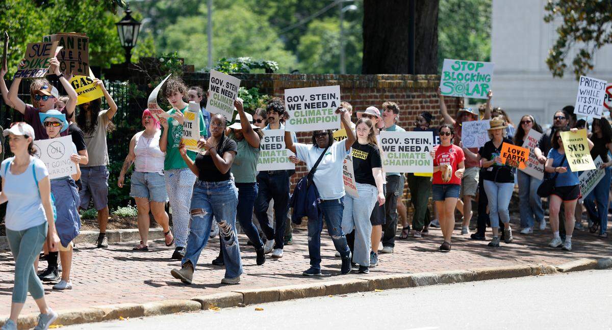 Protesters walk around the N.C. Executive Mansion during a rally and march organized by NC WARN in Raleigh on Saturday.