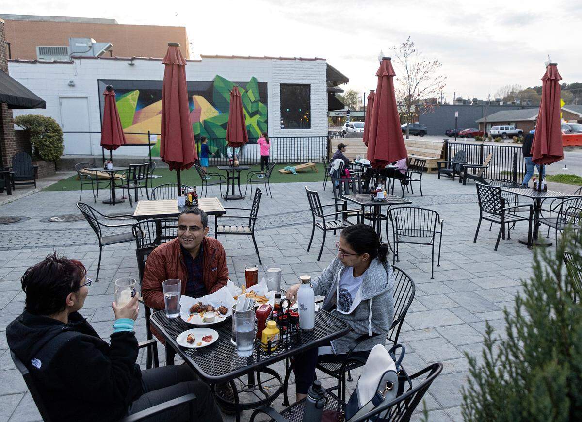 Chandni Malhotra, Shikhin and Meghna Malhotra dine on the patio at Crosstown Pub & Grill on Thursday, March 16, 2023, in Cary, N.C.