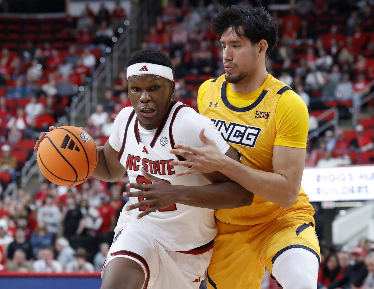 N.C. State’s Ven-Allen Lubin drives past UNC Greensboro Spartans forward Valentino Pinedo during the first half of the Wolfpack’s 110-64 win on Wednesday, Nov. 12, 2025, at Lenovo Center in Raleigh, N.C.