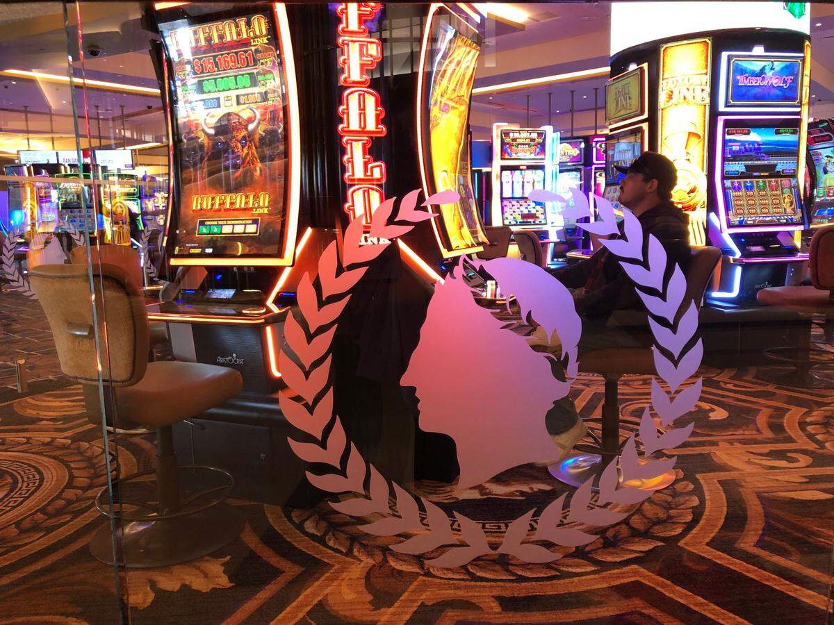 A guest enjoys one of nearly 1,500 slot machines on the gaming floor at Caesars Virginia on opening day, Dec. 17, 2024. The casino and hotel are just three miles from North Carolina in Danville, Va.,