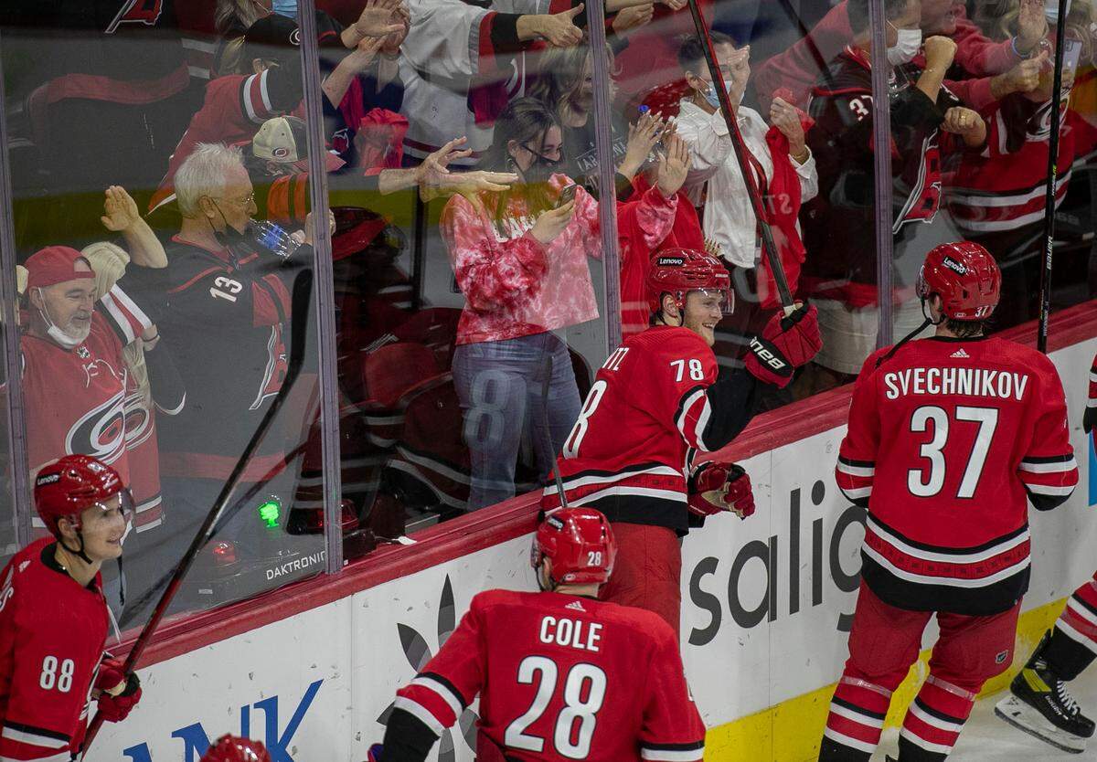 Carolina Hurricane players, Steven Lorentz (78) and Andrei Svechnikov (37) crash the boards as they celebrate their 6-3 victory over the New York Islanders on Thursday, October 14, 2021 at PNC Arena in Raleigh, N.C.