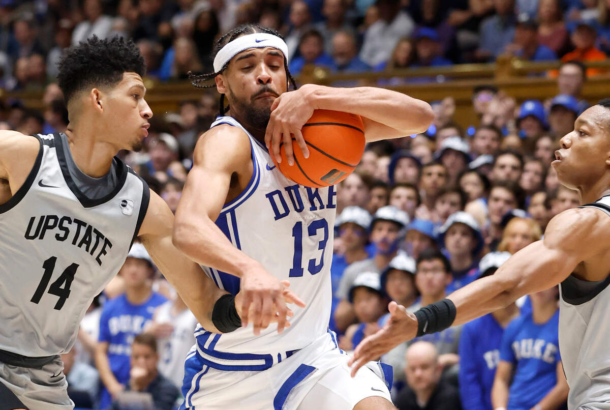 Duke’s Jacob Grandison (13) drives by USC Upstate’s Floyd Rideau Jr. (14) during the first half of Duke’s game against USC Upstate at Cameron Indoor Stadium in Durham, N.C., Friday, Nov. 11, 2022.