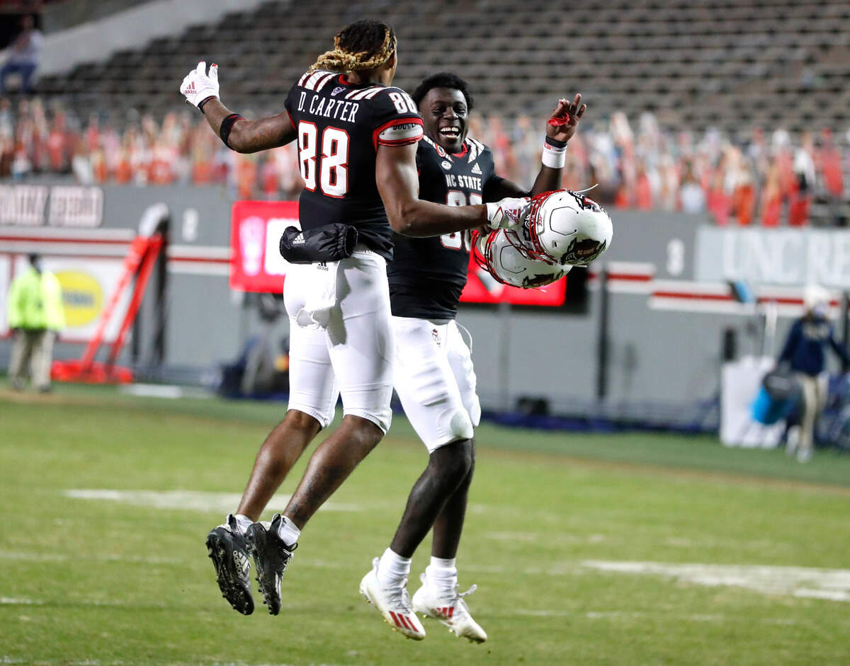 N.C. State’s Emeka Emezie (86) celebrates with Devin Carter (88) after N.C. State’s 23-13 victory over Georgia Tech at Carter-Finley Stadium in Raleigh, N.C., Saturday, Dec. 5, 2020.