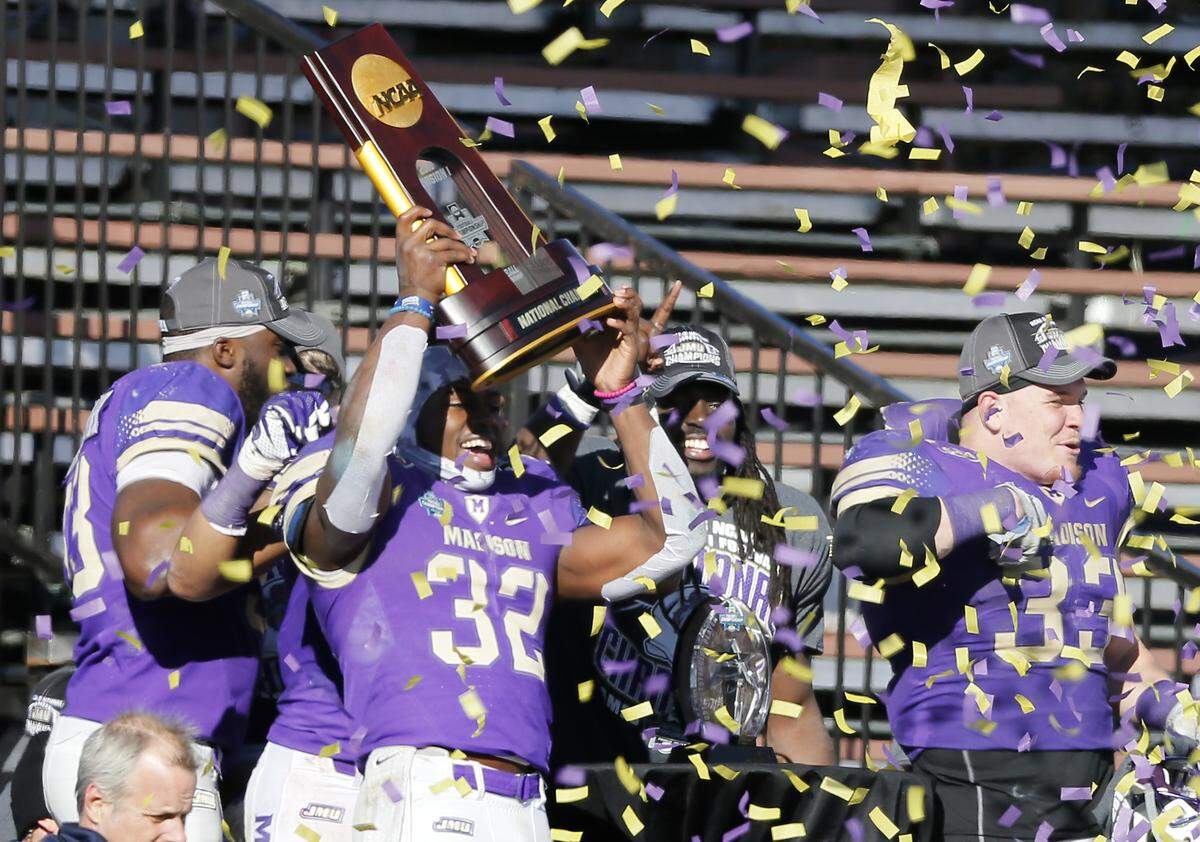 James Madison’s Khalid Abdullah (32) holds up the trophy as he and teammates celebrate their 28-14 win against Youngstown State in the FCS championship NCAA college football game, Saturday, Jan. 7, 2017, in Frisco, Texas.