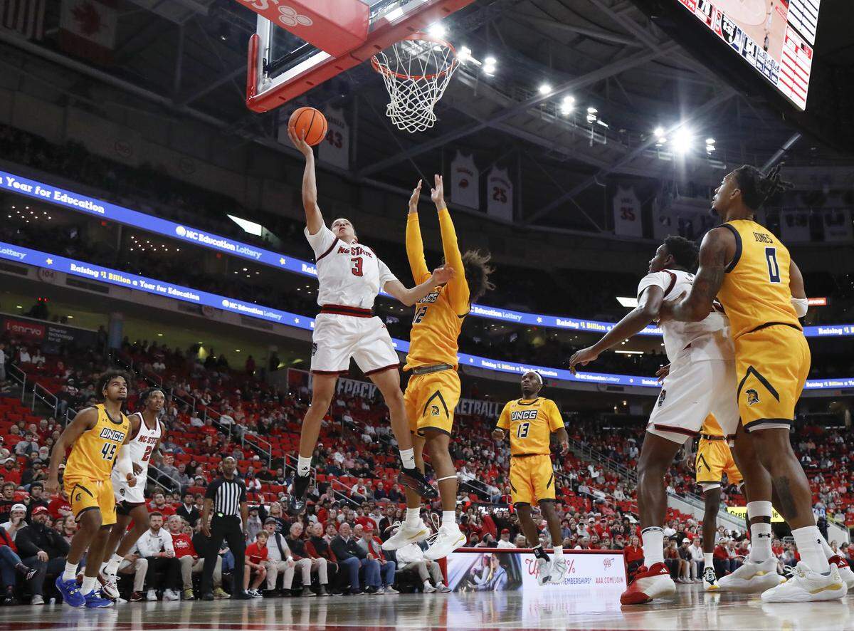 N.C. State’s Matt Able drives to the basket [ast UNC Greensboro’s Justin Neely during the second half of the Wolfpack’s 110-64 win on Wednesday, Nov. 12, 2025, at Lenovo Center in Raleigh, N.C.