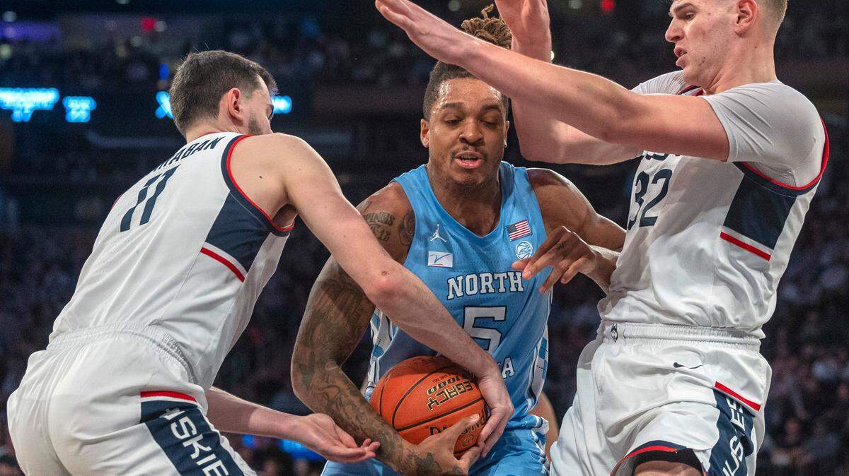 Connecticut’s Alex Karaban (11) and Donovan Clingan (32) grab grab North Carolina’s Armando Bacot (5) during the second half in the Jimmy V Classic on Tuesday, December 5, 2023 at Madison Square Garden in New York, NY.
