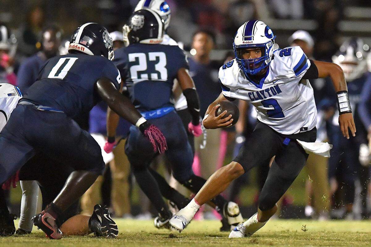 Clayton quarterback Aiden Smalls (2) scrambles for yards against Southeast Raleigh linebacker J'Siah Harden (0) during the first half. The Southeast Raleigh Bulldogs and the Clayton Comets met in a non-conference football game in Raleigh, N.C. October 3, 2025