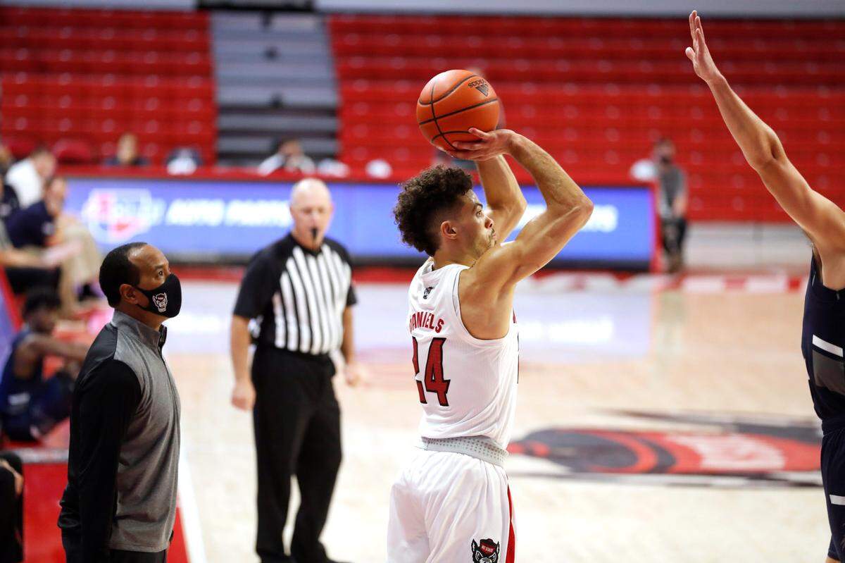 N.C. State’s head coach Kevin Keatts watches as Devon Daniels (24) prepares to shoot during the second half of N.C. State’s 86-51 victory over North Florida in the Mako Medical Wolfpack Invitational at Reynolds Coliseum in Raleigh, N.C., Friday, Nov. 27, 2020.