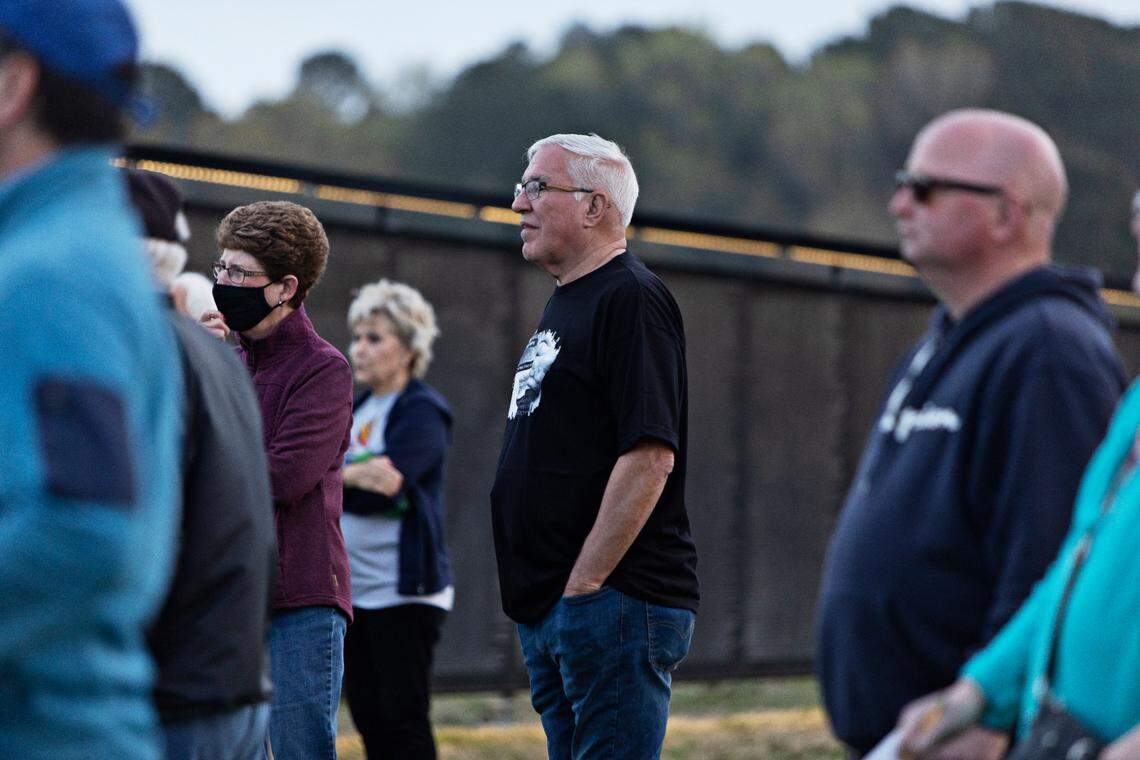 Former News & Observer sports writer Tim Stevens, center, at The Wall That Heals at Garner’s Lake Benson Park on March 30, 2022. Stevens helped organize the traveling three-quarter scale replica of the Vietnam Veterans Memorial that includes the names of the 58,276 men and women who died in Vietnam.