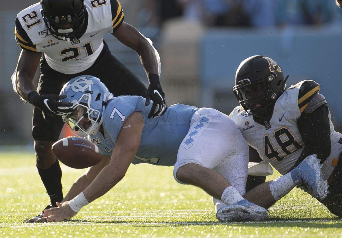 Appalachian State’s Ryan Huff (21) and Demetrius Taylor (48) sack North Carolina quarterback Sam Howell (7) for a loss of three yards and force a fumble which North Carolina recovered in the third quarter on Saturday, September 21, 2019 at Kenan Stadium in Chapel Hill, N.C.