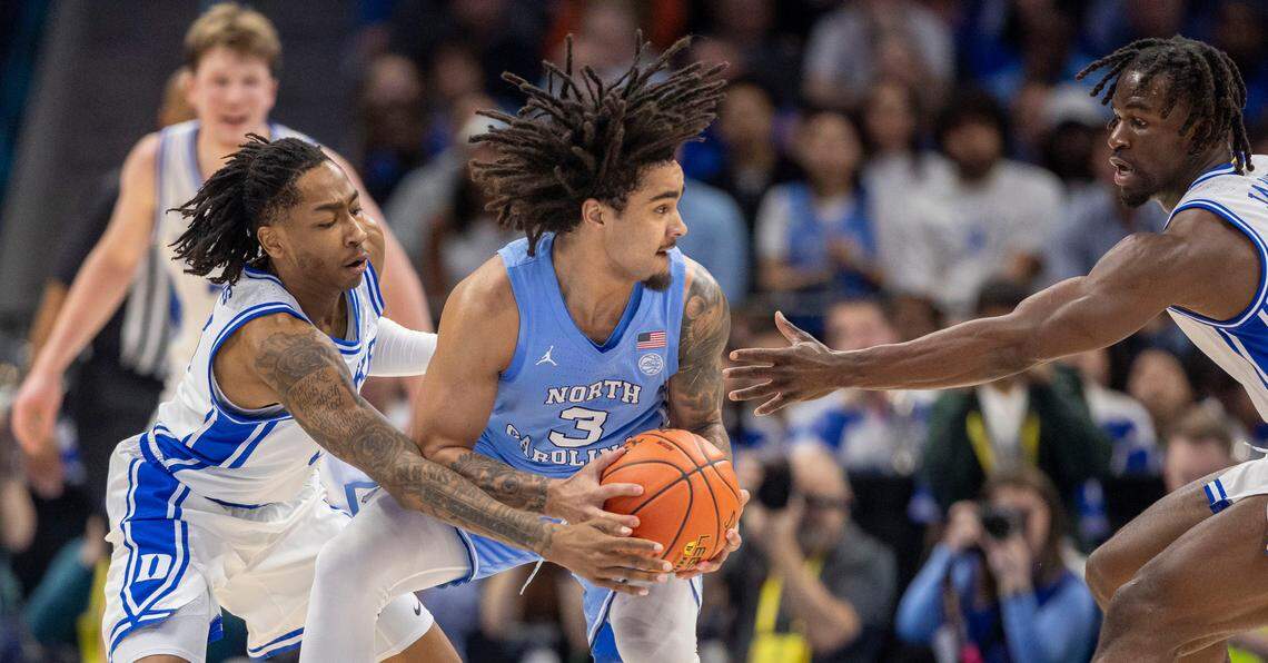 Duke’s Isaiah Evans (3) and Sion James (14) trap North Carolina guard Elliot Cadeau (3) in the first half on Friday, March 14, 2025 during the semifinals of the ACC Tournament at Spectrum Center in Charlotte, N.C.