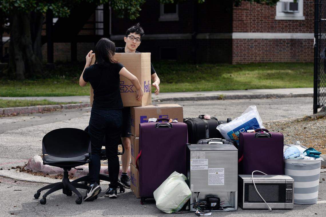 Duke freshmen Feng Cong from Singapore and Cassie Lu from Thailand carry a box to a pile of their belongings as they move out of his dorm at Duke University. Sunday, March 15, 2020. Cong will be returning home to Singapore and Lu to Thailand since students are being asked to move out and complete classes online for the rest of the semester due to coronavirus.