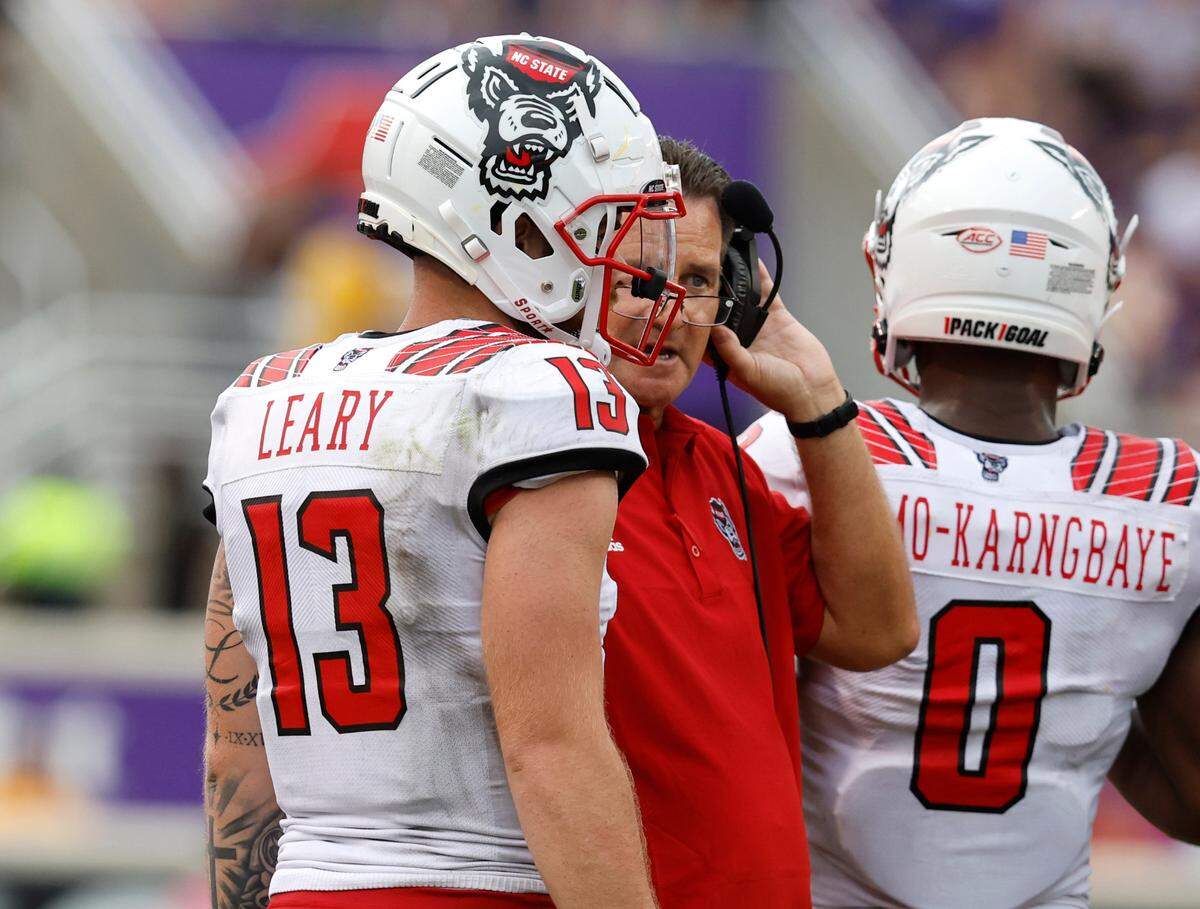 N.C. State quarterback Devin Leary (13) talks with offensive coordinator Tim Beck during the second half of N.C. State’s 21-20 victory over ECU at Dowdy-Ficklen Stadium in Greenville, N.C., Saturday, Sept. 3, 2022.