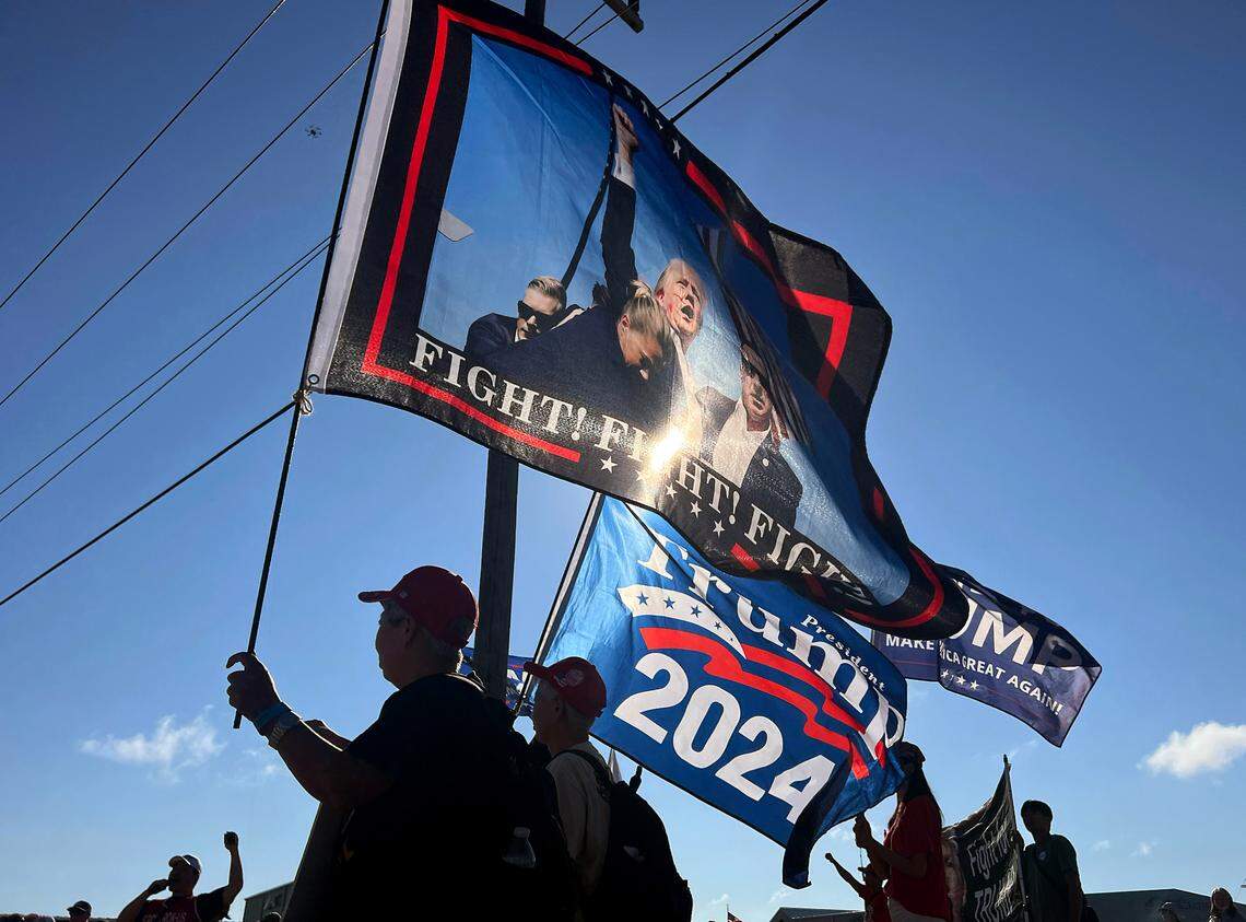 People hold flags outside of Aero Center Wilmington prior to remarks by former President and current Republican candidate for president Donald Trump on Saturday, Sept. 21, 2024 in Wilmington, N.C.