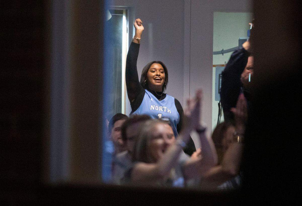 Alexis Tyson, a sophomore at UNC-Chapel Hill, cheers as she watches basketball players walk onto the court in New Orleans from Top of the Hill in Chapel Hill, N.C. on Saturday, April 2, 2022.