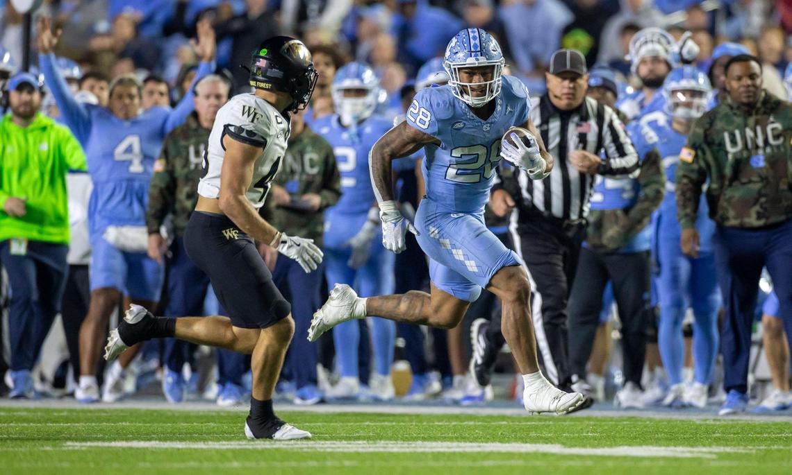 North Carolina running back Omarion Hampton (28) breaks ahead of Wake Forest defensive back Nick Andersen (45) for 38-yard gain in the third quarter on Saturday, November 16, 2024 at Kenan Stadium in Chapel Hill, N.C. Hampton had a career night rushing for 244 yards and one touchdown.