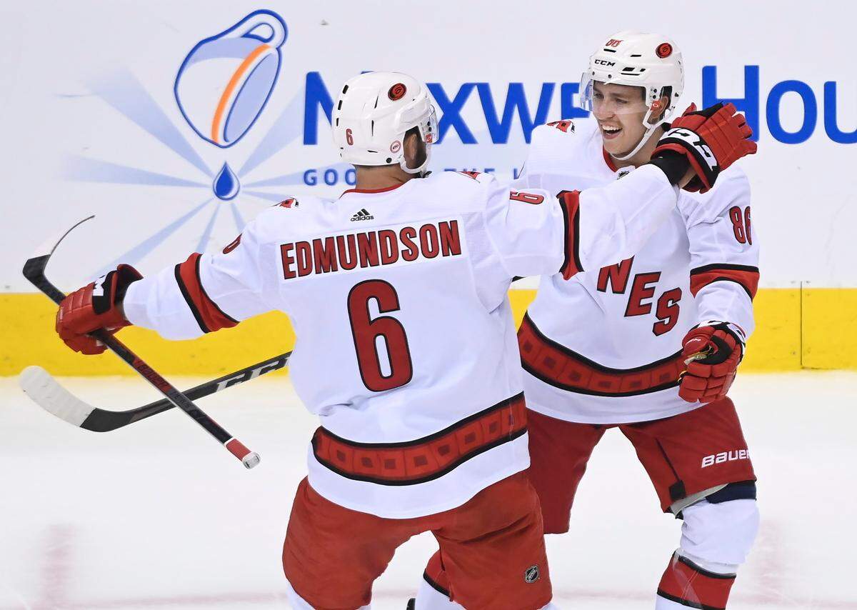 Carolina Hurricanes defenseman Joel Edmundson (6) celebrates his goal with teammate Teuvo Teravainen (86) during the first period of an NHL hockey Eastern Conference Stanley Cup playoff game in Toronto, Wednesday, Aug. 12, 2020. T(Nathan Denette/The Canadian Press via AP)