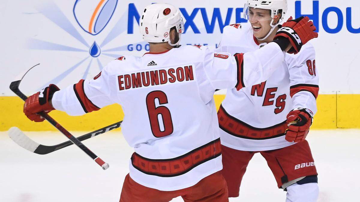 Carolina Hurricanes defenseman Joel Edmundson (6) celebrates his goal with teammate Teuvo Teravainen (86) during the first period of an NHL hockey Eastern Conference Stanley Cup playoff game in Toronto, Wednesday, Aug. 12, 2020. T(Nathan Denette/The Canadian Press via AP)